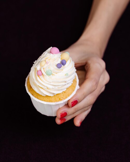 Photo hand holds a bright cake