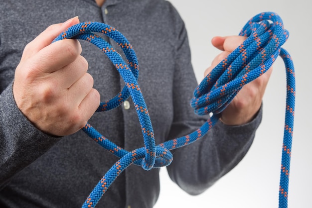 La mano tiene la corda colorata per l'attrezzatura da arrampicata. oggetto per il campeggio e l'arrampicata