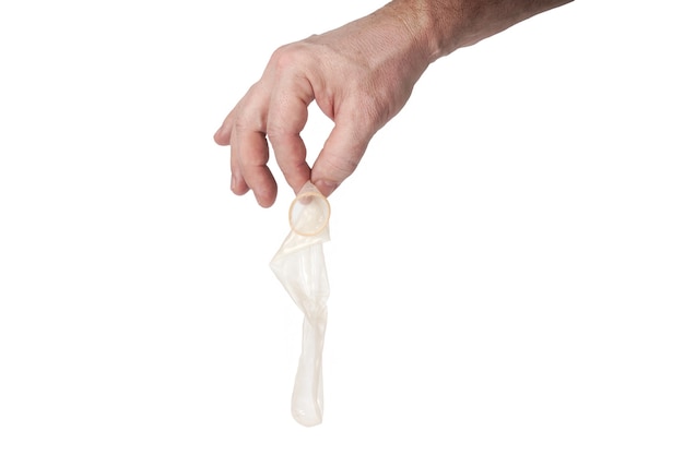 Hand holds a condom on a white background