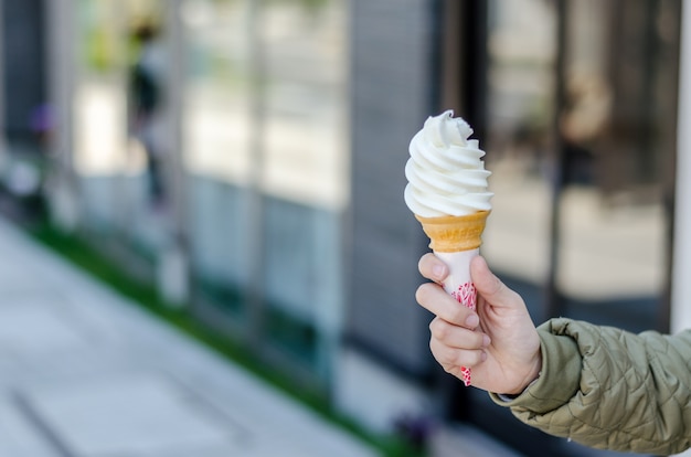 Hand holds conemilk ice cream at Otaru City