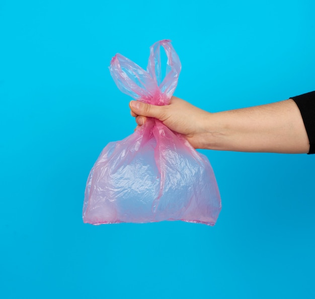 Hand holds an empty pink plastic bag