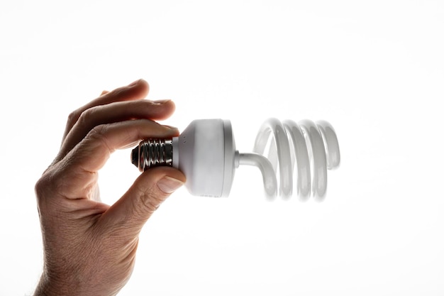 The hand holds an energy-saving light bulb. mercury light bulb