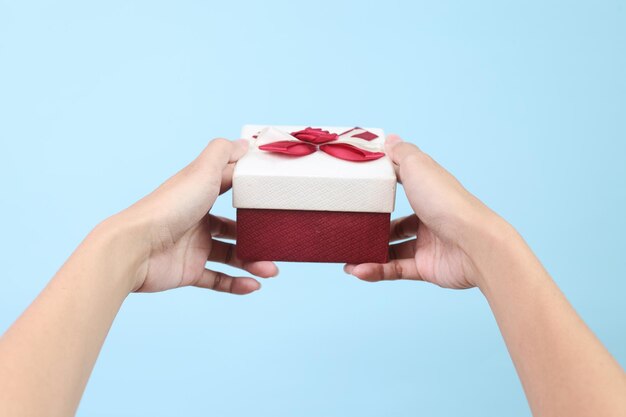 Photo hand holds gift box isolated on blue background