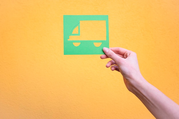 Photo hand holds green truck symbol