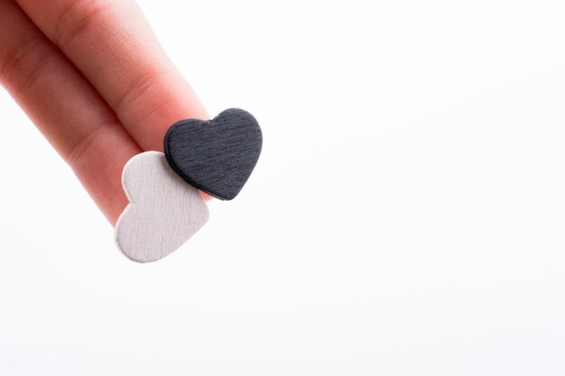 A hand holds a heart with a white background.