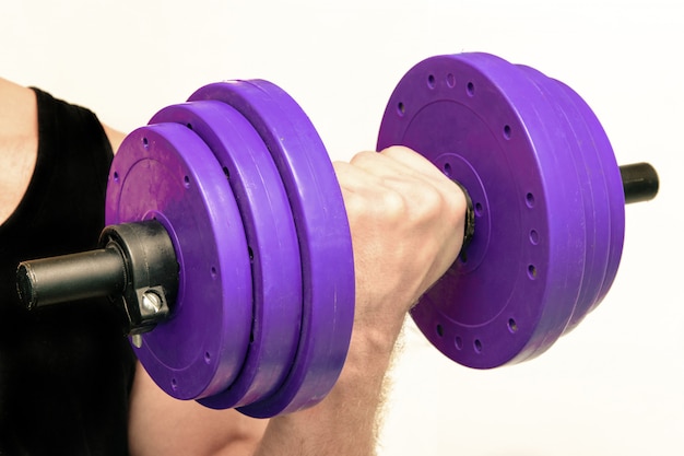 Hand holds a heavy dumbbell on an isolated background