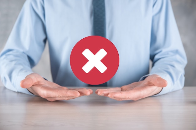 Hand holds icon,cancellation symbol,cancel icon.Cross mark flat red icon.round X mark.cancel button.Wrong.cross mark rejection.Declined.On dark background.Banner.Copy space.Place for text.