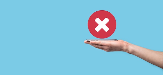 Hand holds icon,cancellation symbol,cancel icon.Cross mark flat red icon.round X mark.cancel button.Wrong.cross mark rejection.Declined.On dark background.Banner.Copy space.Place for text.