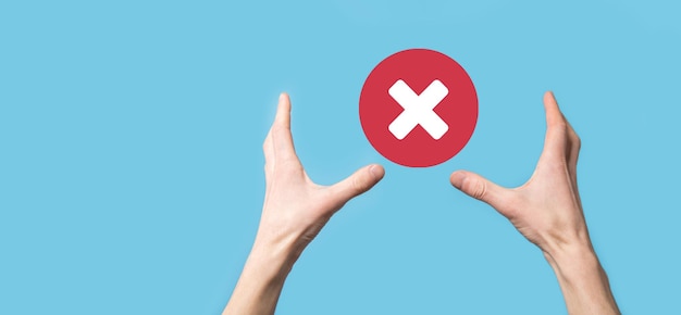 Hand holds icon,cancellation symbol,cancel icon.Cross mark flat red icon.round X mark.cancel button.Wrong.cross mark rejection.Declined.On dark background.Banner.Copy space.Place for text.