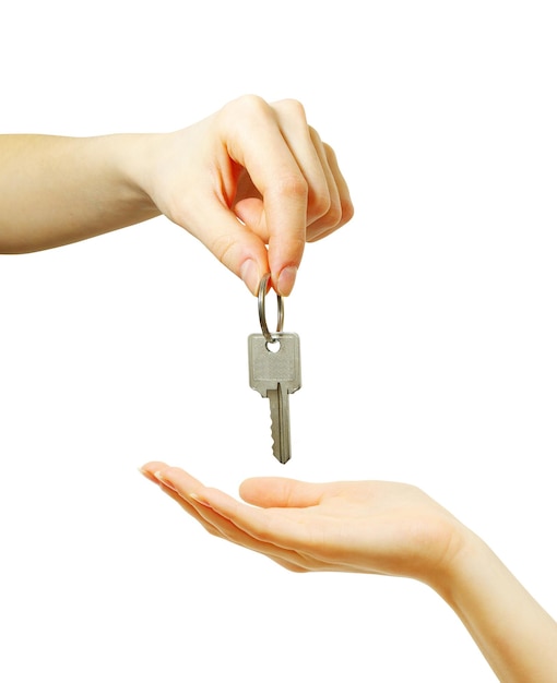 Hand holds a key isolated on white