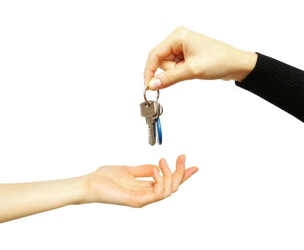 Hand holds a key isolated on white