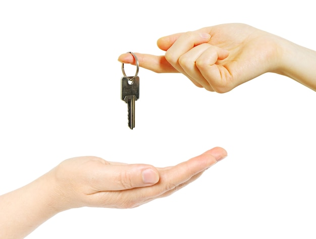 Hand holds a key isolated on white