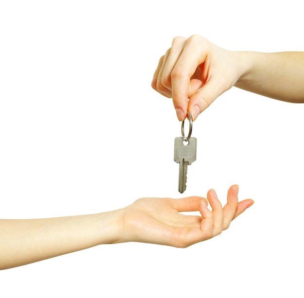 Hand holds a key isolated on white