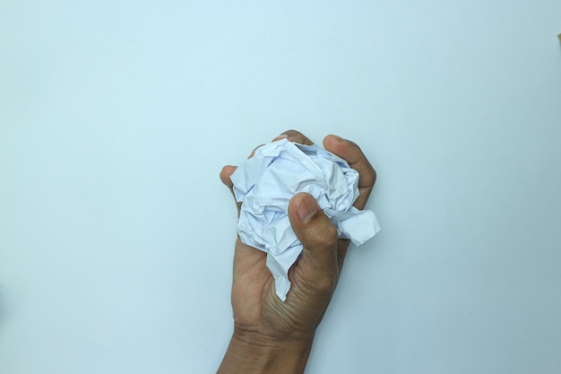 The hand holds a lump of white paper. Isolated on white background.