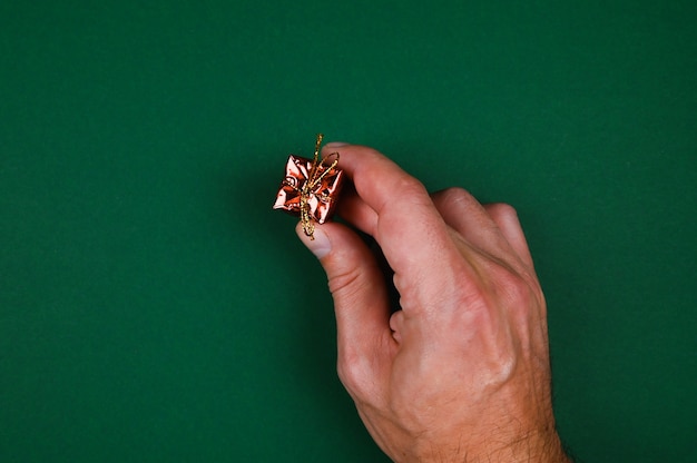 Hand holds a New Year's gift on a green background. High quality photo