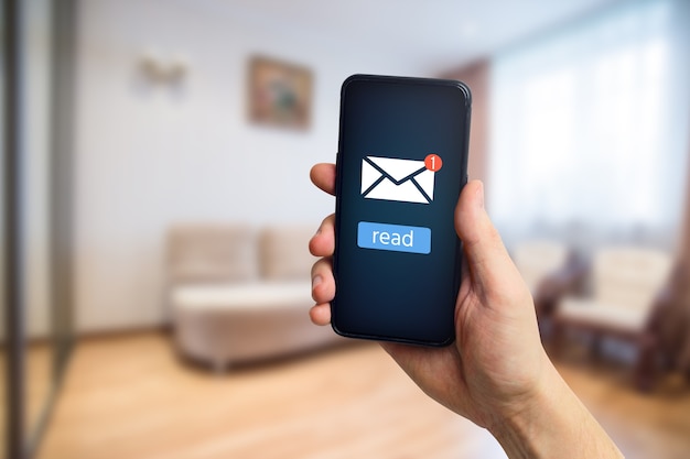 Photo hand holds phone with concept of reading new email