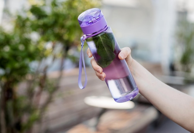 Hand holds a refreshing drink with mint