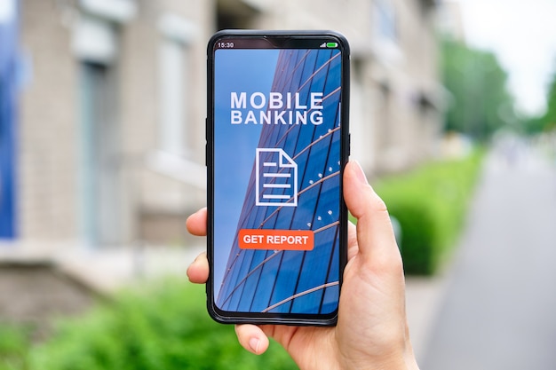 Photo hand holds smartphone with mobile banking interface and click to get a report on financial transactions.