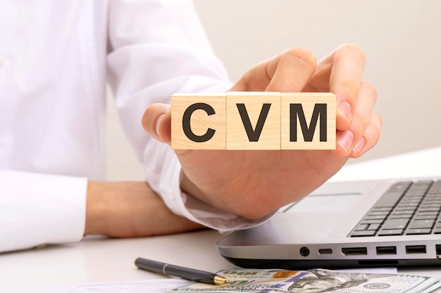 手は、碑文 cvm ホワイト バック グラウンド顧客価値管理の概念と木製の立方体を保持します