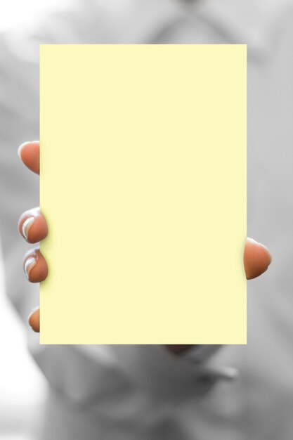 Foto la mano tiene il biglietto da visita in bianco giallo a fuoco