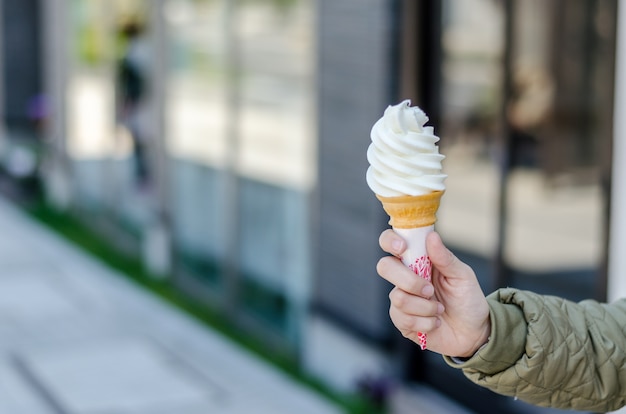 Hand houdt conemilk-ijs in Otaru City