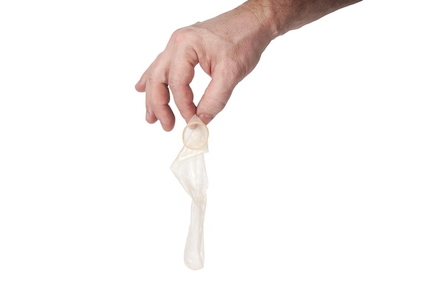 Hand houdt een condoom op een witte achtergrond