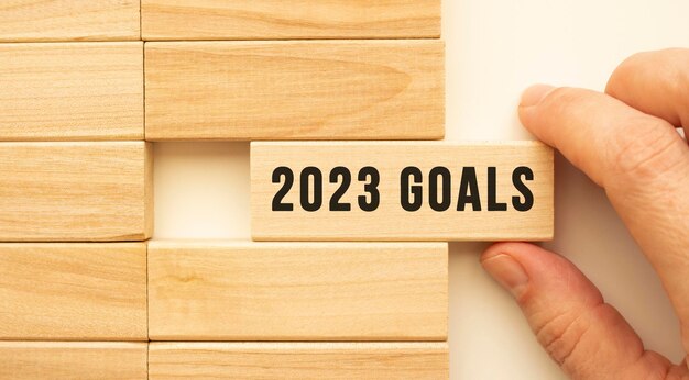 Foto hand houdt een houten kubus vast met de tekst 2023 goals