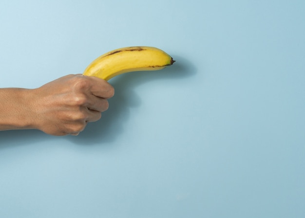 Hand houdt een man banaan vast met een kopieerruimte.