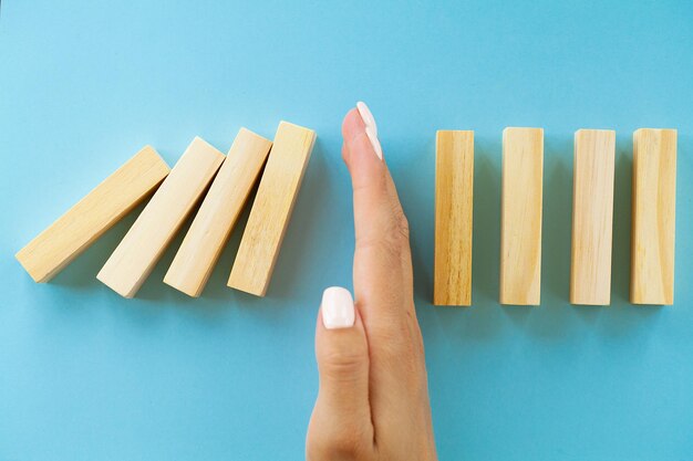 Hand houdt houten blokken het concept van het stoppen van de crisis vast