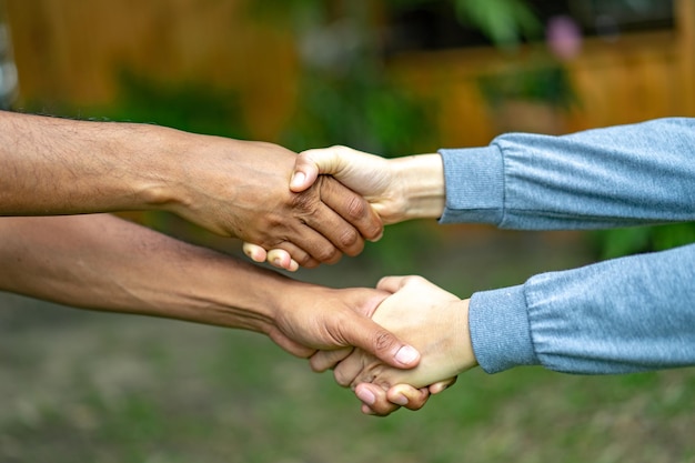 Hand houdt samen in de gemeenschap in de tuin/park.