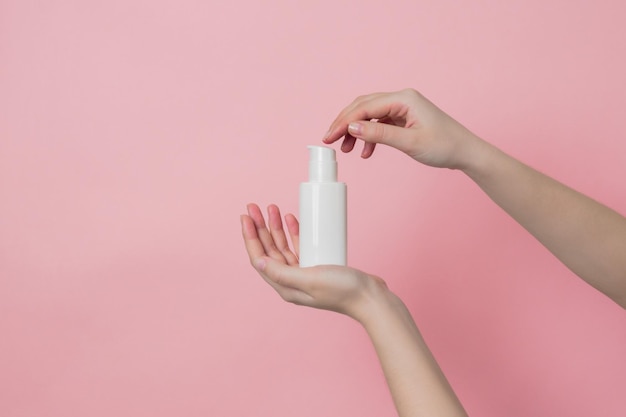 Hand houdt witte crème fles met pomp Concept van schoonheid Dagelijks schoonheidsproduct