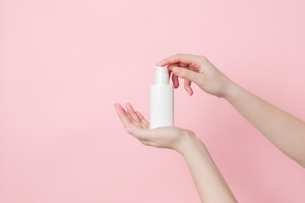 Hand houdt witte crème fles met pomp Concept van schoonheid Dagelijks schoonheidsproduct