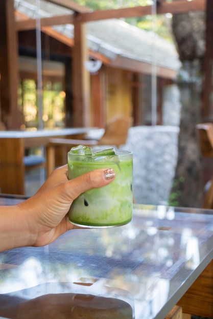 Hand on iced matcha green tea drink