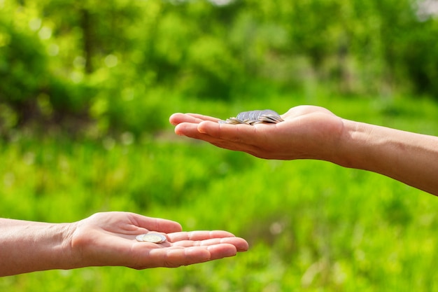 Hand in hand geeft munten op groene achtergrond, Financiën concept en leningen.