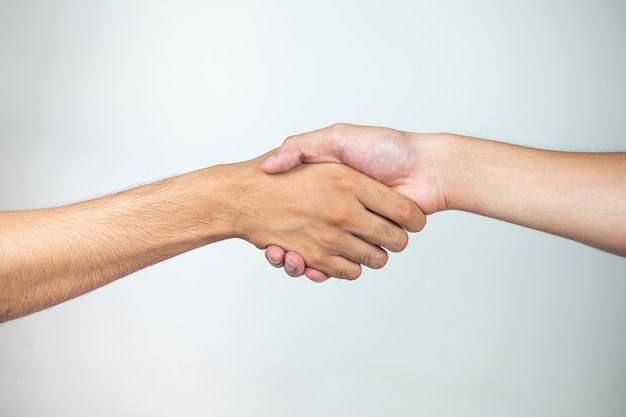 Hand in hand van twee mannen op een witte ondergrond