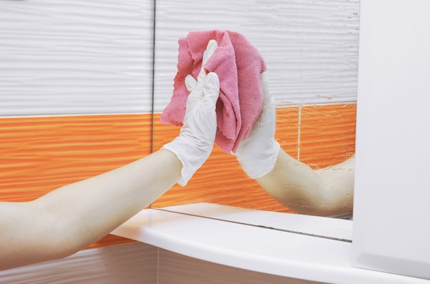 Hand in handschoen wassen van een spiegel