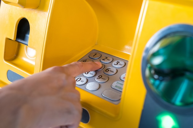 Foto hand indrukken van de code van de atm richt zich op de cijfers en de vinger gebied.