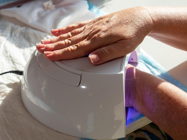 Hand inserted into gel lamp machine for permanent nail paints