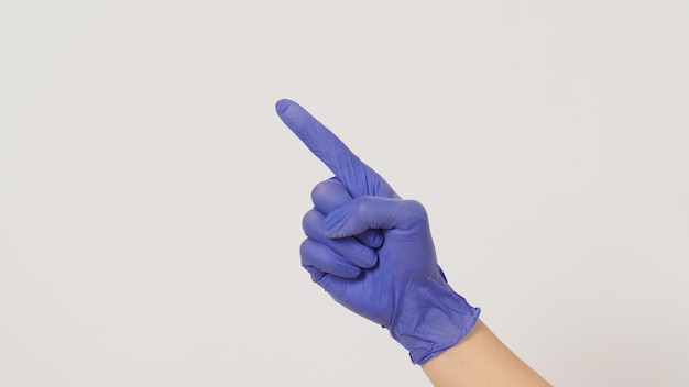 Hand is doing point finger hand sign on white background Hand wear violet or purple latex glove