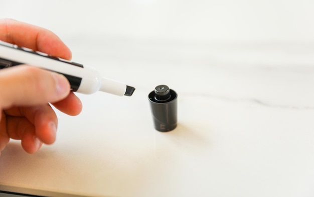 A hand is drawing a black and white pen with a black cap.