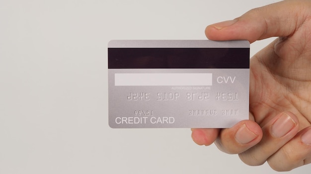 Hand is hold back of silver credit card on white\
background