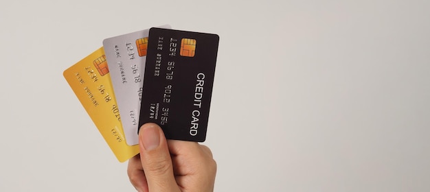 Рука держит три кредитные карты на белом фоне