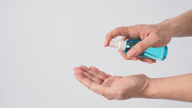 Photo hand is holding alcohol spray on white background.