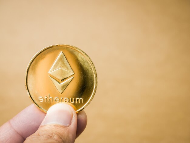 Hand is holding ethereum coin.