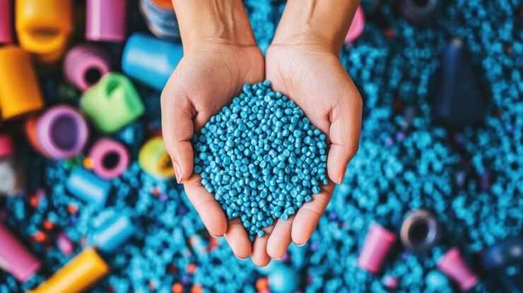 A hand is holding a handful of blue beads The beads are in a variety of colors