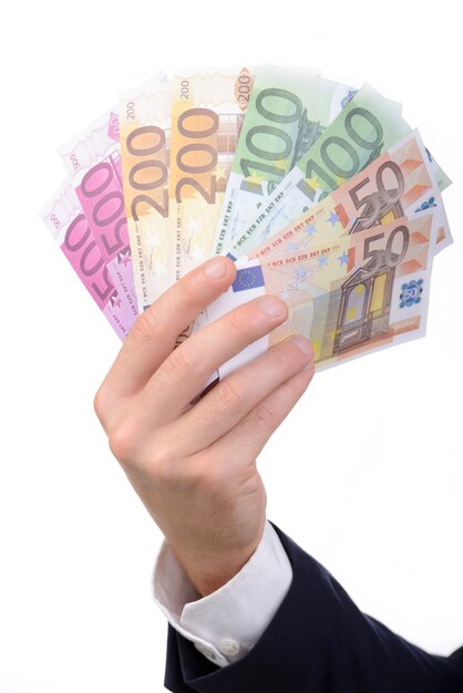 Hand is holding money while standing isolated on white.