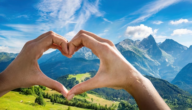 hand is making a heart gesture with mountains and blue sky