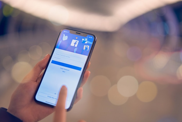 Photo hand is pressing the facebook screen on smartphone