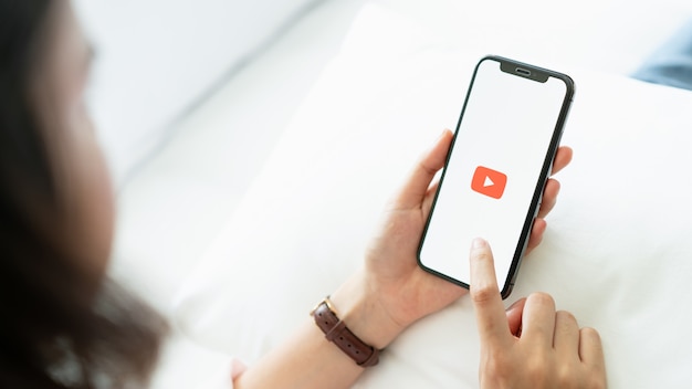 hand is pressing the screen displays the Youtube app icons