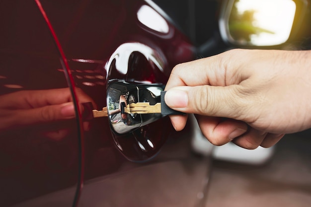 Hand is unlocking car door with the key in garage close up